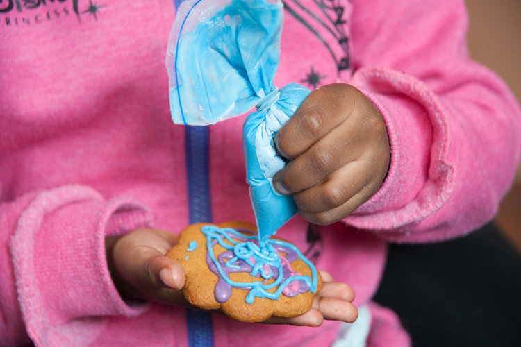Little girl decorating christmas bakings.