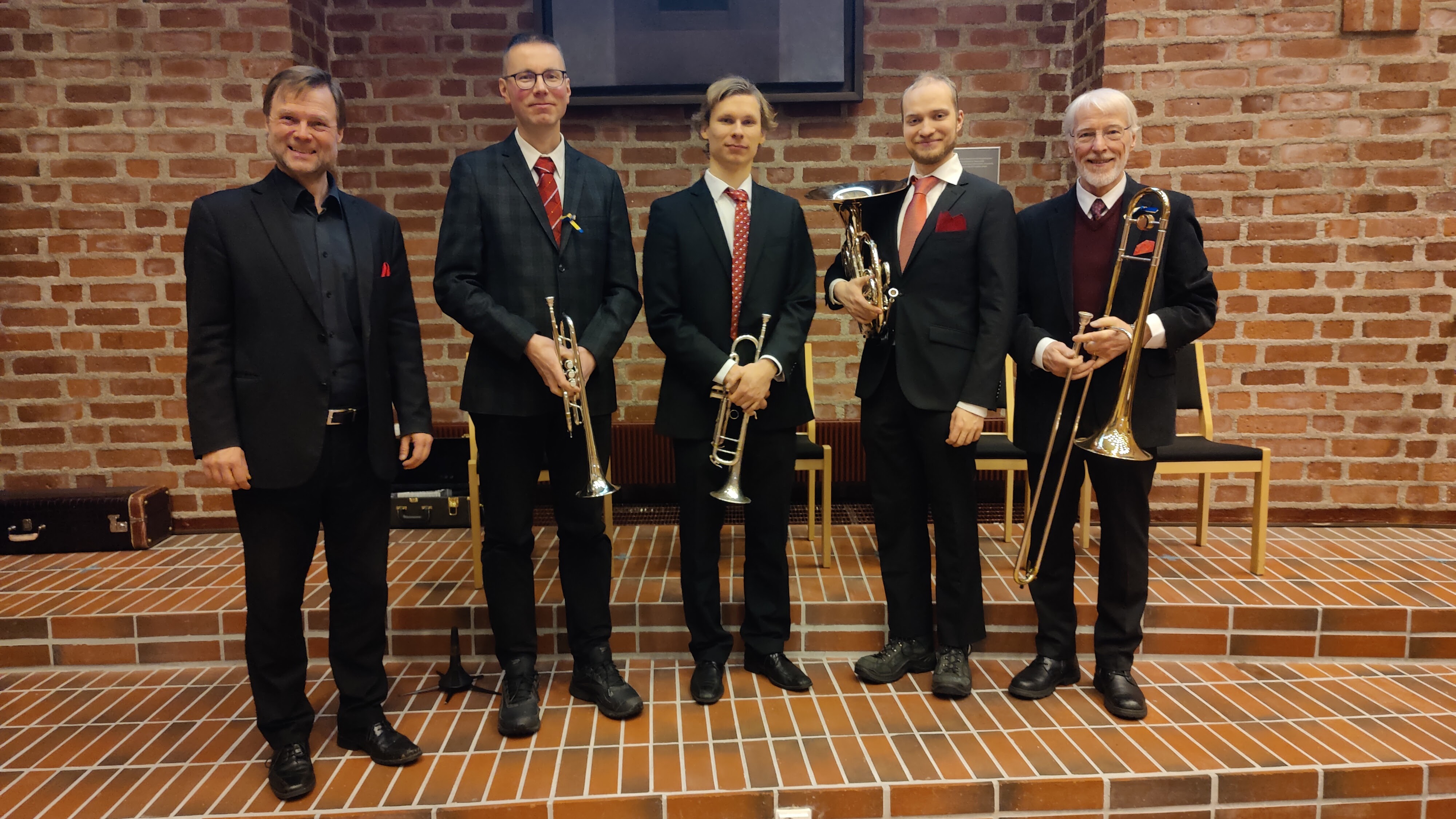 Vaskiyhtye Pilgrim Brassin viisi soittajaa yhteiskuvassa soittimet kädessään.