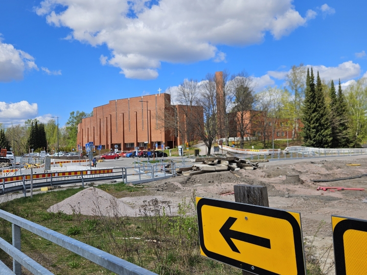 Olarin kirkko, etualalla työmaan kevyenliikenteen opasteita.