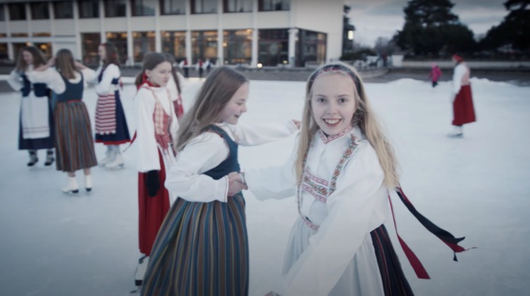 Lapset tanssivat ulkona talvella kansallispuvut yllään.
