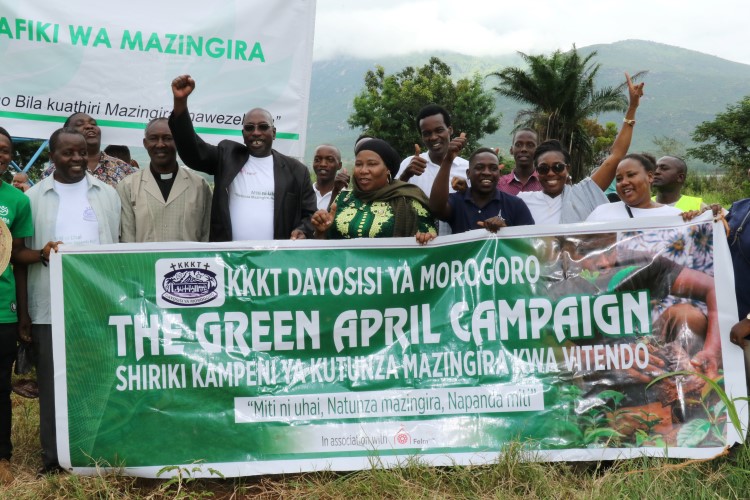 Ryhmä ihmisiä joilla on edessään banderolli tekstillä: The Green April Campaign.