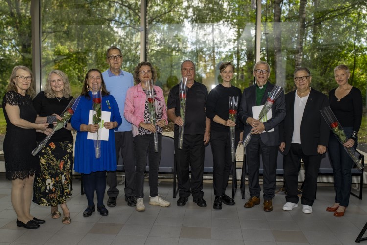 Ryhmäkuvassa ruusujen kanssa Anne Arkonaho, Irene Ponkula-Karlsson, Anne-Maria Laukkarinen, Juha Ilomäki, A...