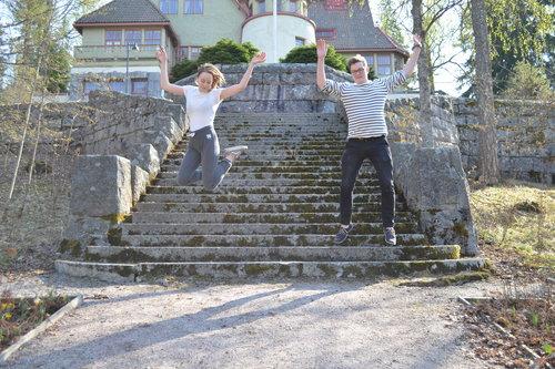Kaksi nuorta hyppää ilmaan Hvittorpin villan portailta.