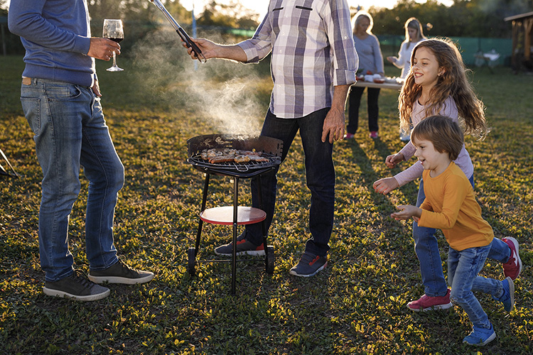 Matinraitin kyläkarnevaali Aikuisia ja lapsia grillaamassa ulkona.