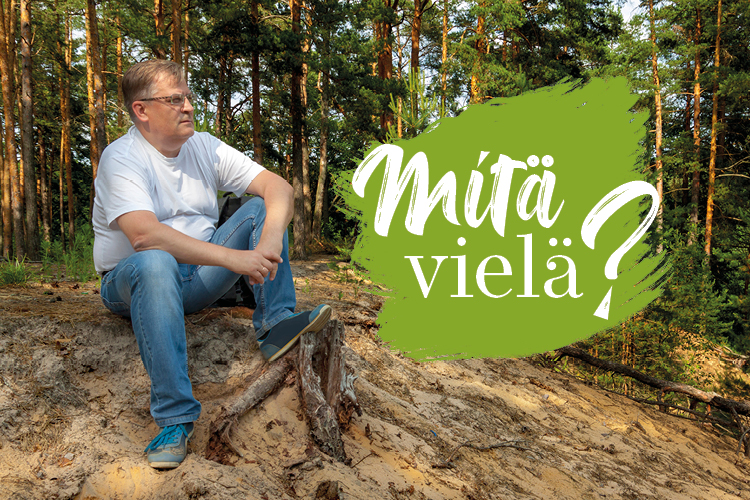 Mies istuu mäntyjen varjossa hiekkaisella harjulla ja katsoo maisemaa, teksti Mitä vielä?