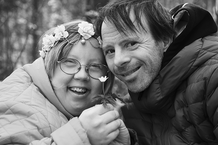 Kaksi kehitysvammaista henkilöä hymyilee.