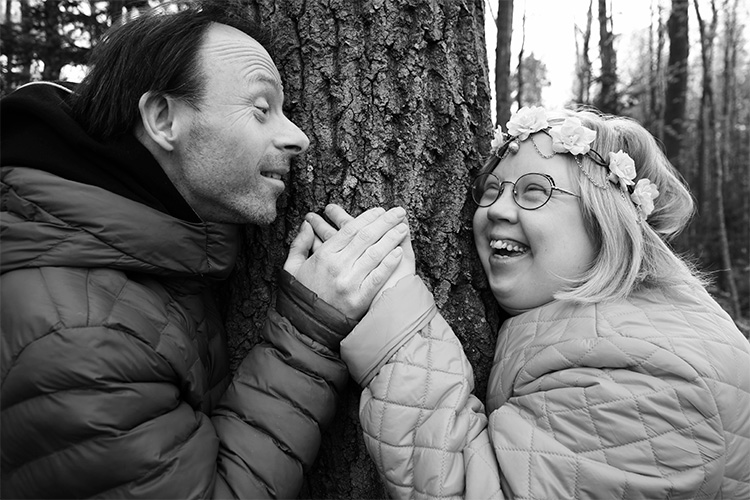 mies ja nainen pitävät toisiaan kädestä kiinni ja hymyilevät onnellisina