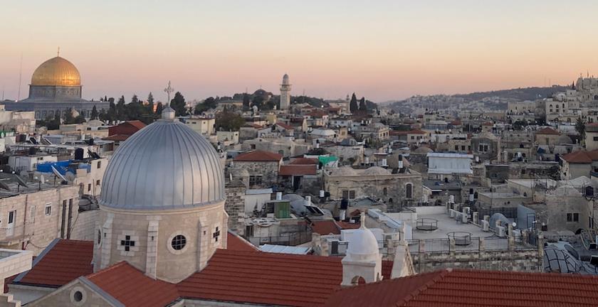 Jerusalemin vanhakaupunki auringonlaskun aikaan. Taustalla näkyy kalliomoskeija ja etulalla kirkko