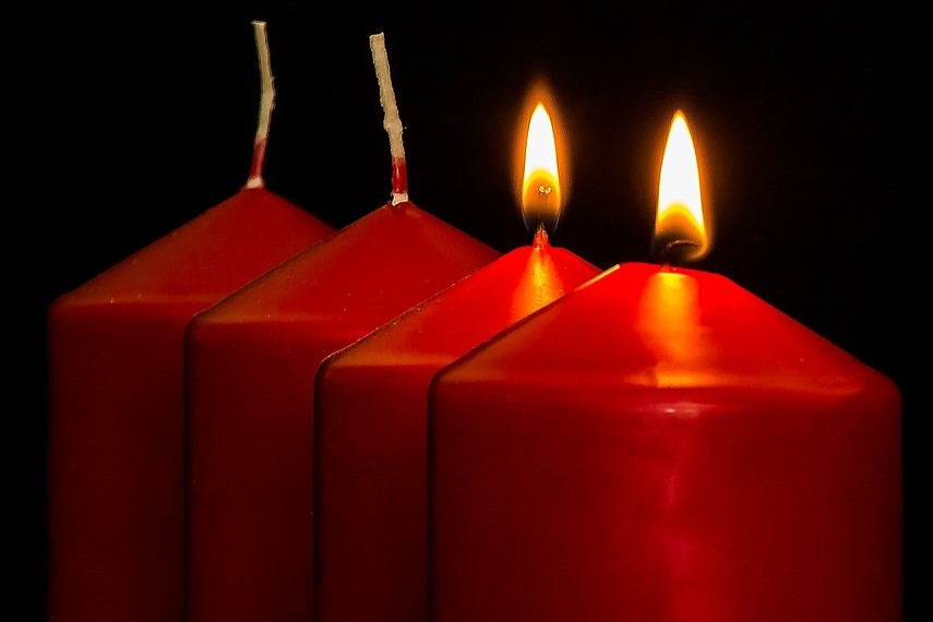 Neljä punaista kynttilää, joista kaksi palaa.