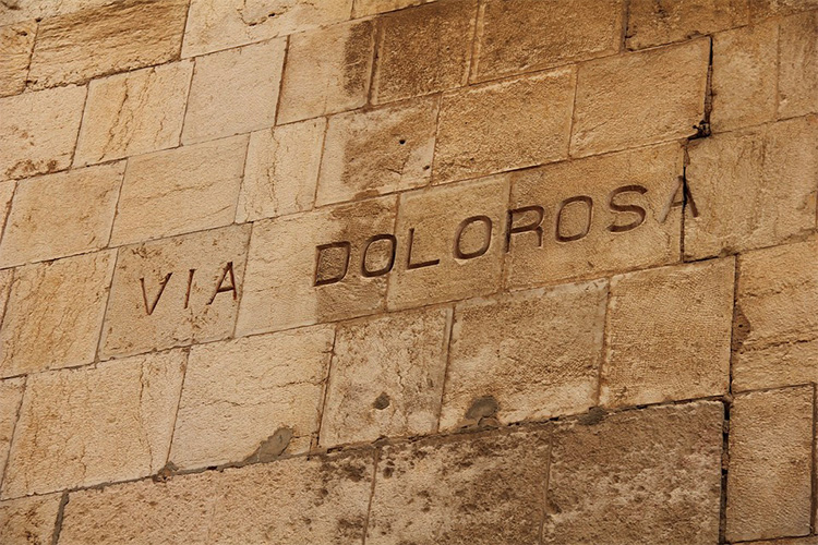 Kuvassa tiiliseinä Jerusalemissa, siinä lukee Via Dolorosa.