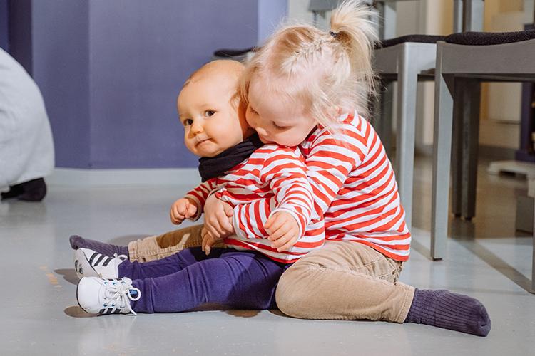 Kirkon perhekahvila Isompi lapsi halaa pienempää lasta