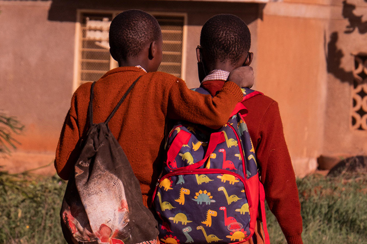 kaksi koulupoikaa reput selässä kulkevat rinnakkaiin