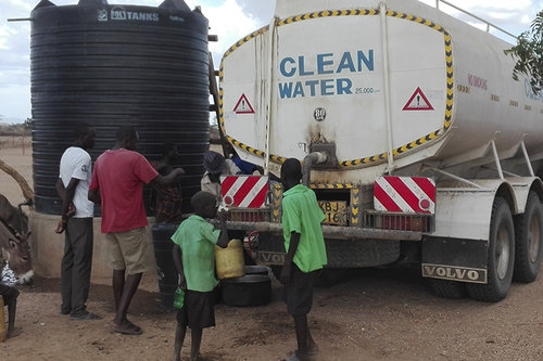 Kuvassa Kirkon Ulkomaanavun työntekijät jakavat vettä alakouluille Keniassa. 