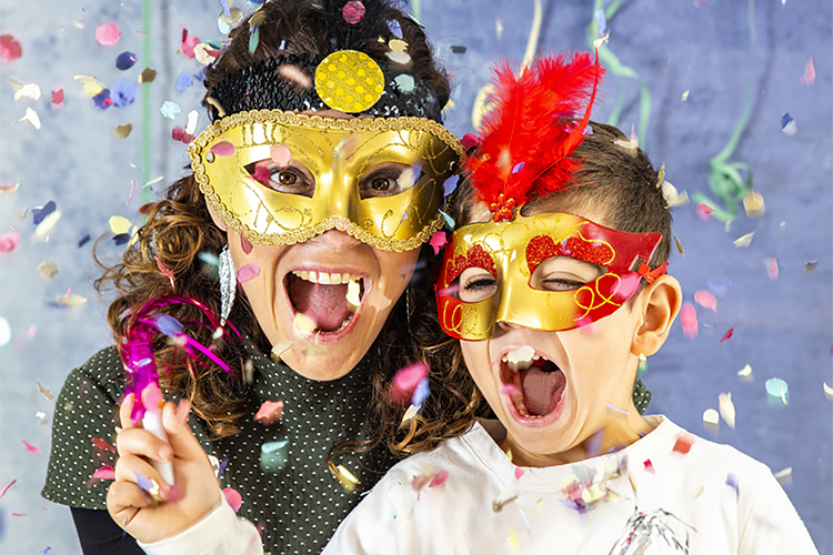 Nainen ja lapsi juhlivat värikkäästä konfettisateessa.