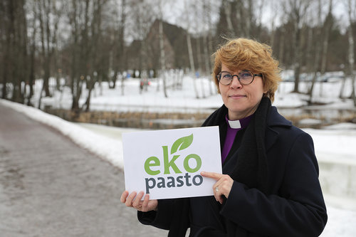 Piispa Kaisamari Hintikka pitää käsissään Ekopaasto-kylttiä.