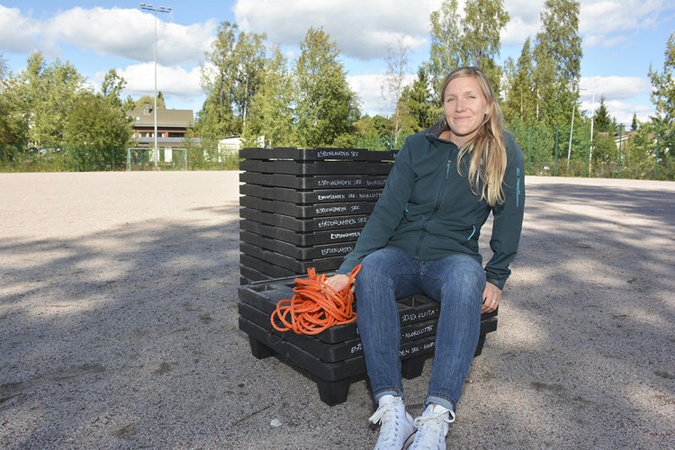 Nuorisotyönohjaaja Siiri Salonen istuu ryhmäytyksessä apuna käytettyjen mustien, siirrettävien lavojen pääl...
