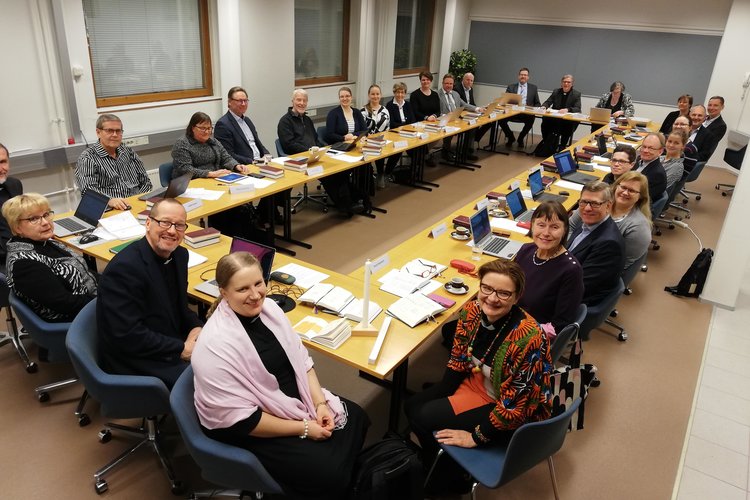 Yhteinen kirkkoneuvosto hymyilee kuvaajalle kokoushuoneessa ennen ensimmäistä kokoustaan 4.2.2019. Kuva: Ei...