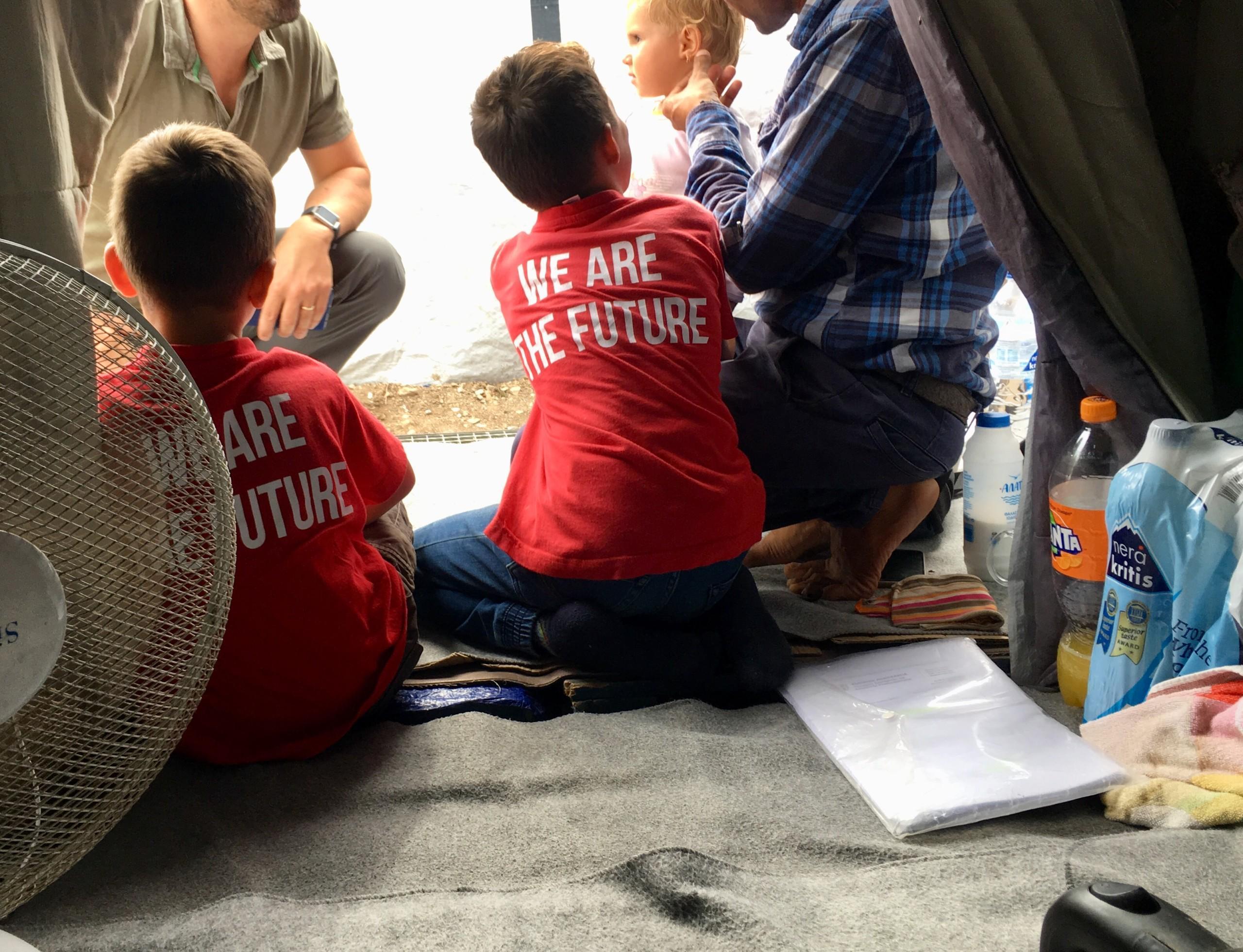 Kreikassa olevan pakolaisleirin teltassa on lapsia, joiden paidassa lukee
