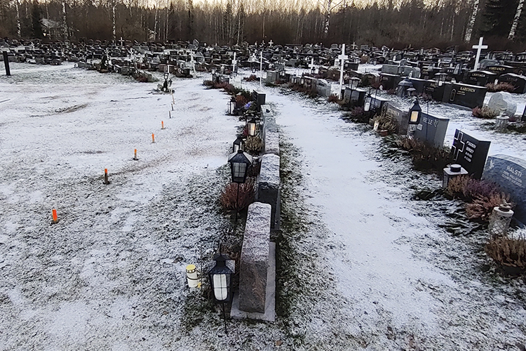 Kuvassa näkyy osittain ohuen lumen peittämiä hautausmaan käytäviä Kellonummelta. Osa käytävistä näyttää liu...