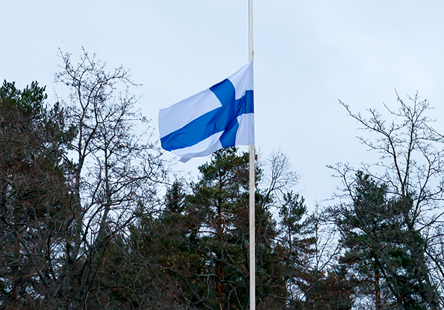 kuvassa on Suomen lippu puolitangossa