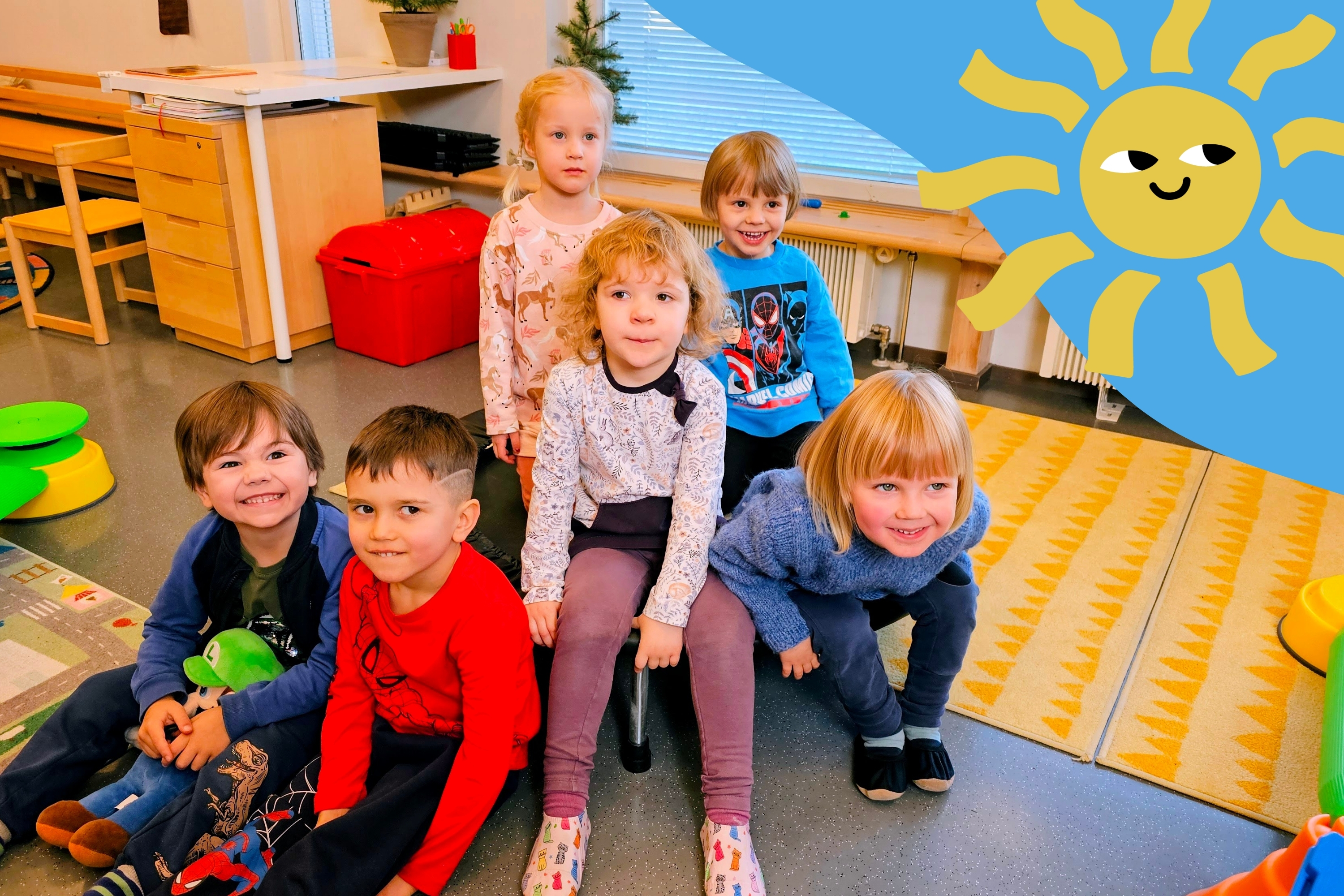 Ryhmä lapsia istuu kerhotilan lattialla.