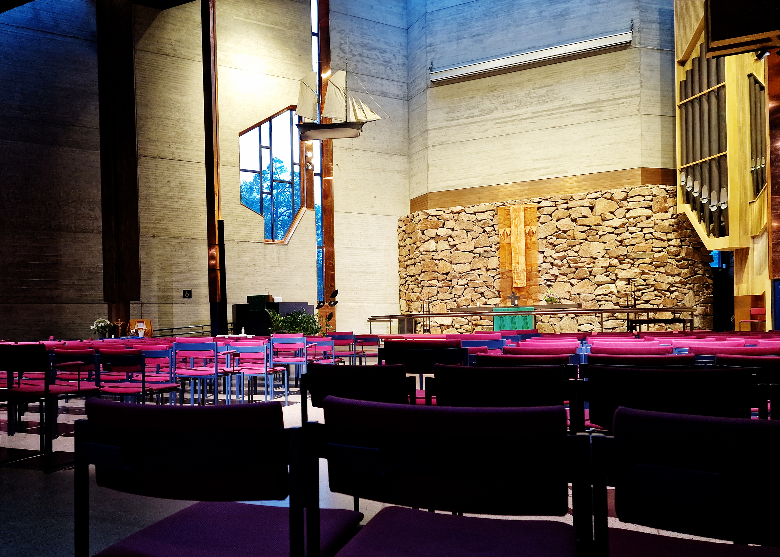 Espoonlahden kirkon luonnonkivistä ja betonista rakennettuun alttariseinään osuu valo.